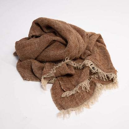Brown textured throw blanket  with frayed edges on a white background