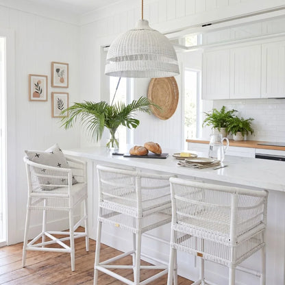 Modern kitchen with white island, stools, and decor elements.