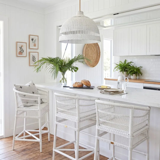Modern kitchen with white island, stools, and decor elements.