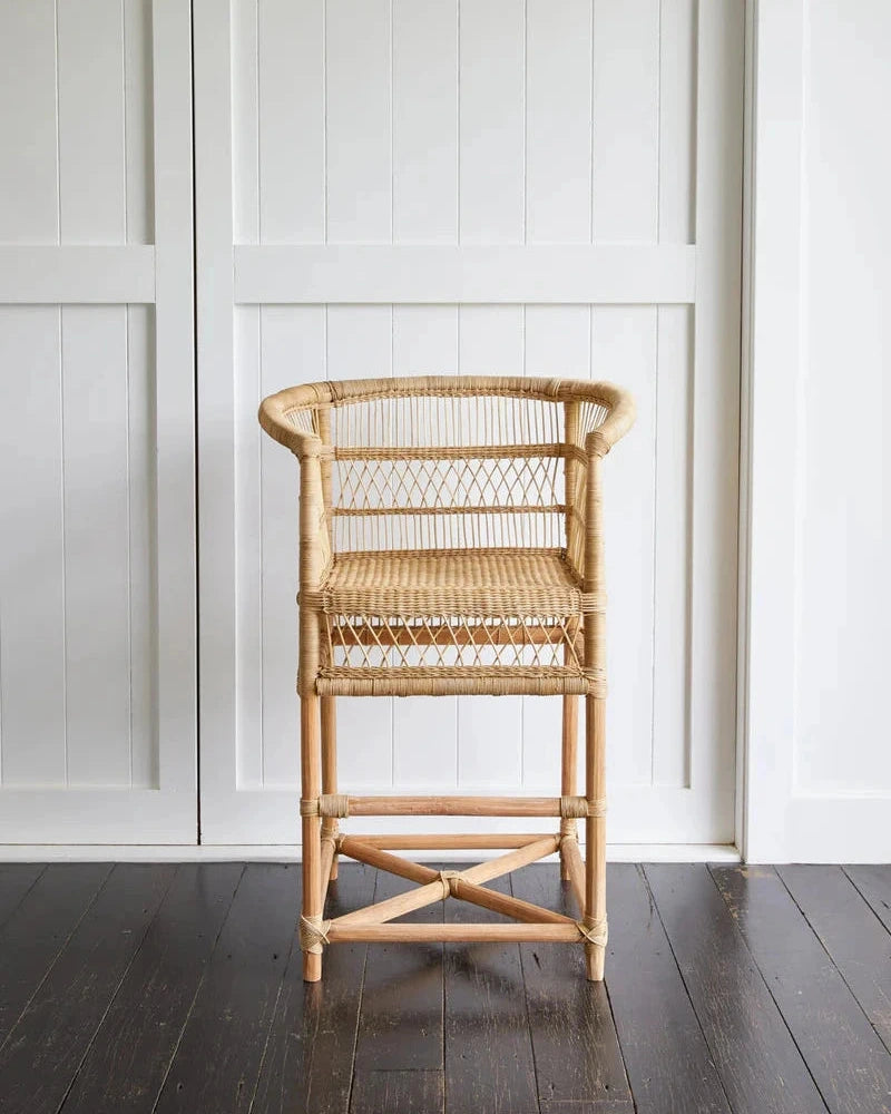 Malawi Cane Counter Stool against a white paneled wall