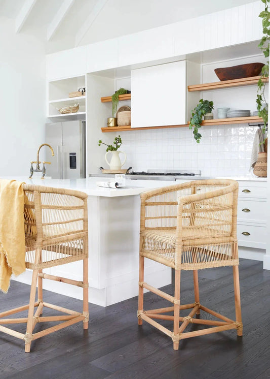 Modern kitchen with white island, Malawi Cane stools and white cabinets.
