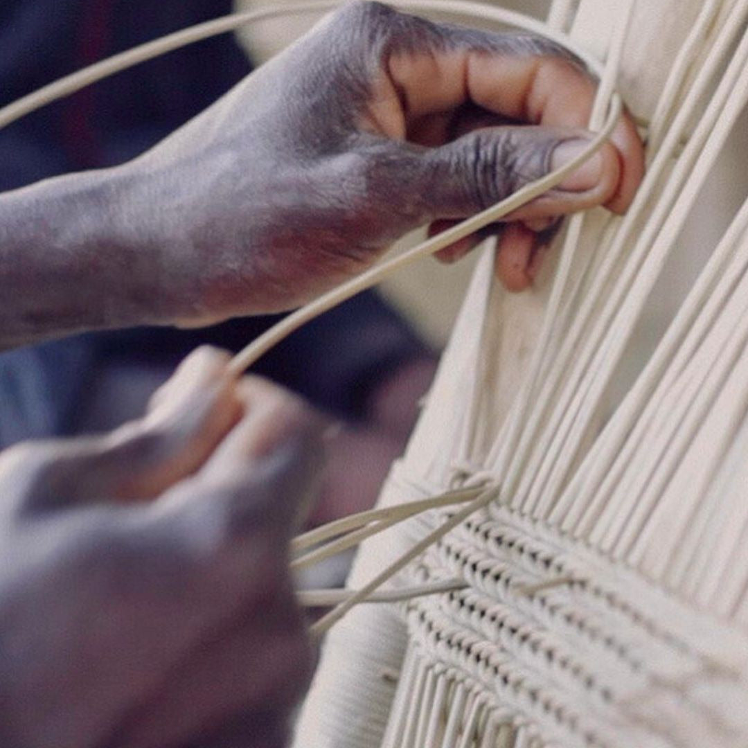 Close-up of hands weaving authentic Malawi cane furniture