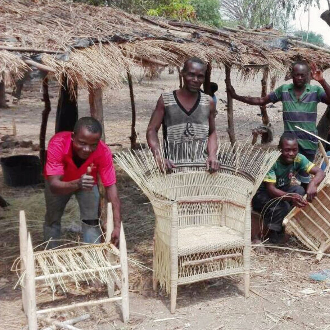 People working with woven furniture in a rustic outdoor setting