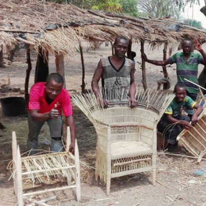 People working with woven furniture in a rustic outdoor setting