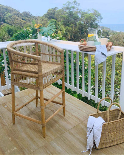Malawi cane stool with a scenic view of trees and mountains on a outdoor deck