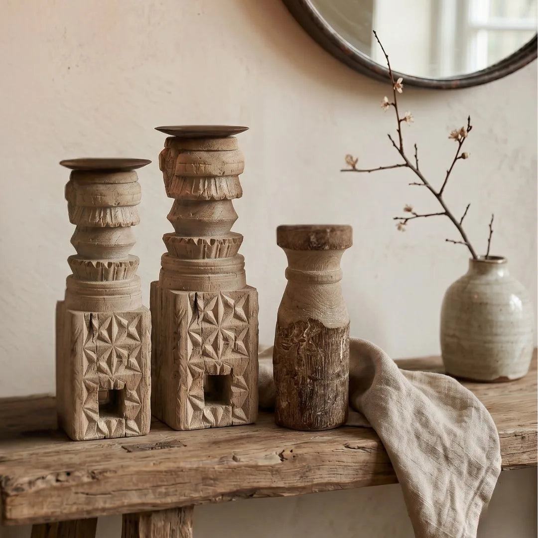 Decorative wooden vases on a wooden surface with a neutral background