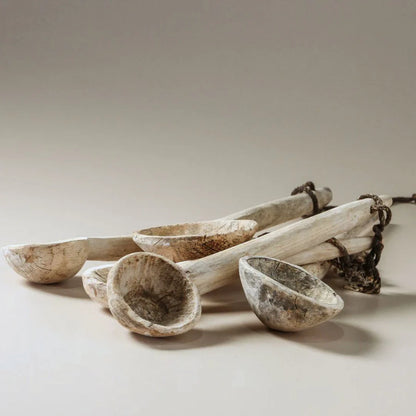 Set of wooden spoons and bowls on a neutral background
