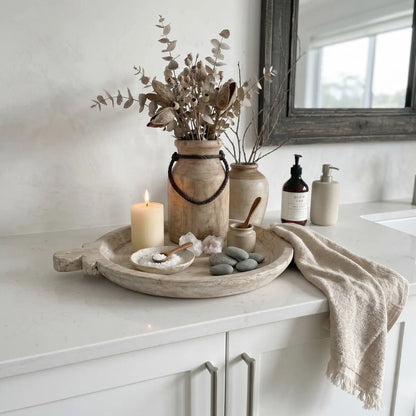 Decorative setup on a kitchen counter with vases, candles, and a tray.
