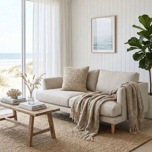 Cozy living room with Wabi textured Natural throw blanket and matching Wabi cushion on a Beige sofa, wooden coffee table, and decorative elements.
