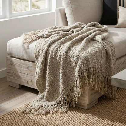Textured Wabi throw blanket on a wooden ottoman in a cozy living room.