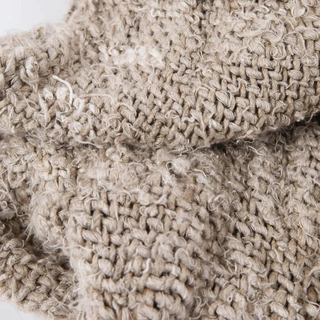 Close-up of a beige knitted blanket with textured pattern