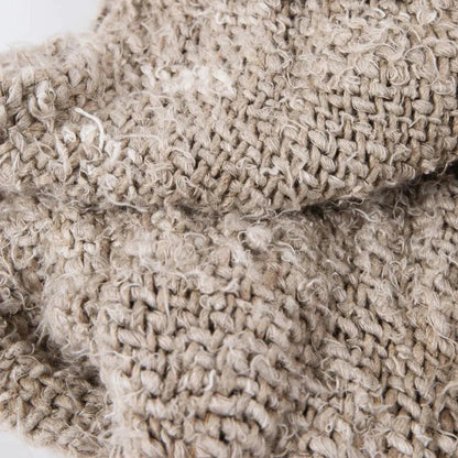 Close-up of a beige knitted blanket with textured pattern