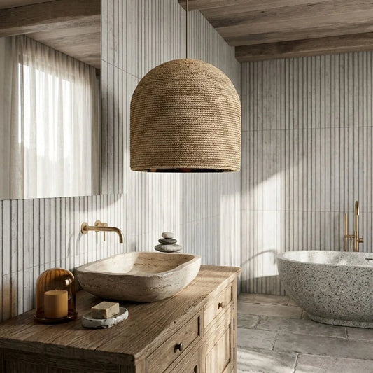 Bathroom with wooden vanity, stone sink, and wicker pendant light.