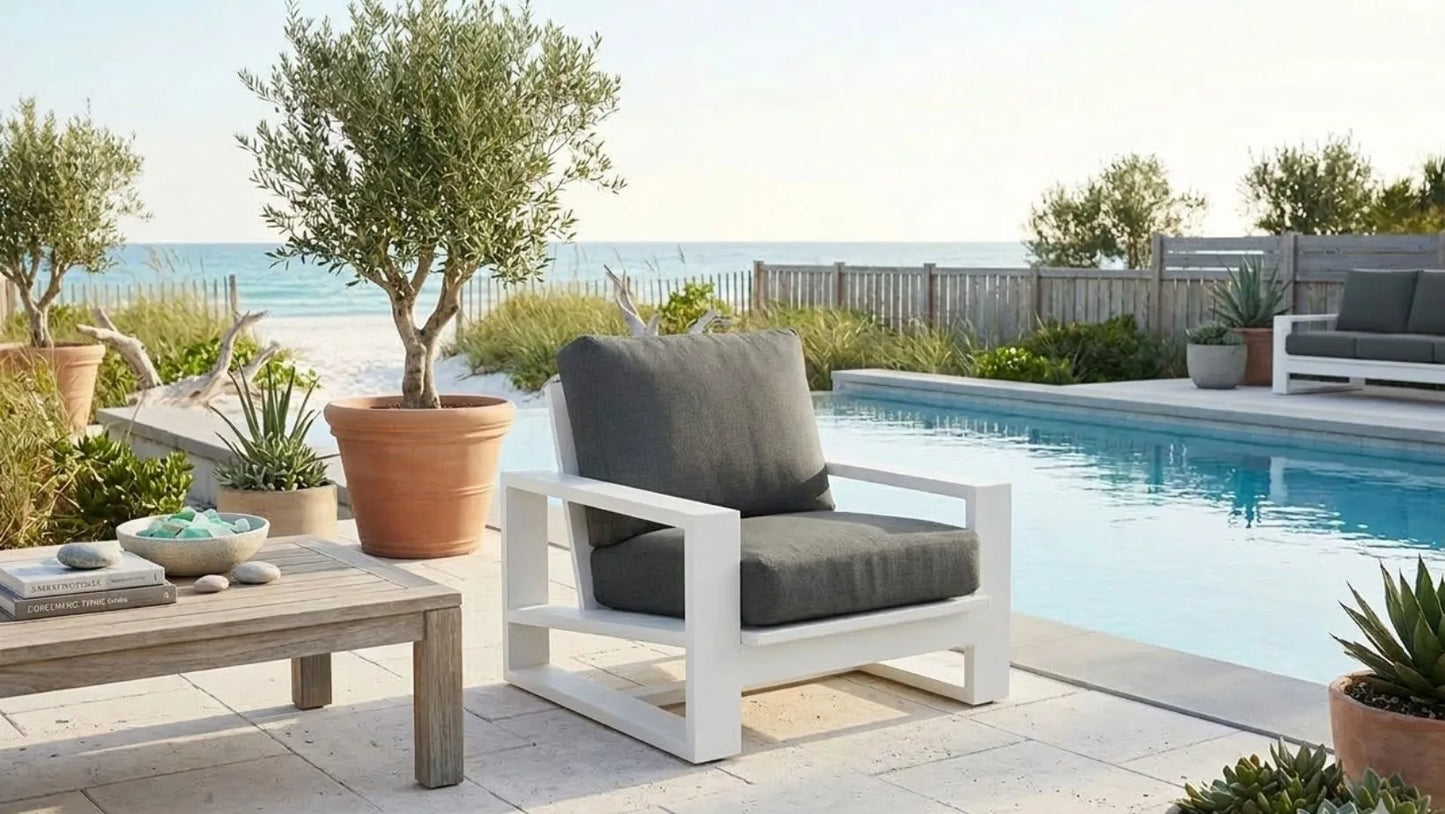 Outdoor patio furniture by a pool with a scenic ocean view.
