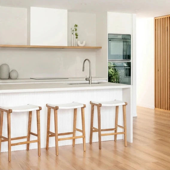 Modern kitchen with white island ans white leather and teak counter stools