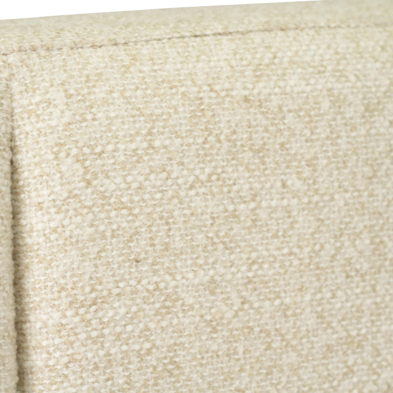 Close-up of a textured beige fabric upholstery with a vertical channel tufting seam.
