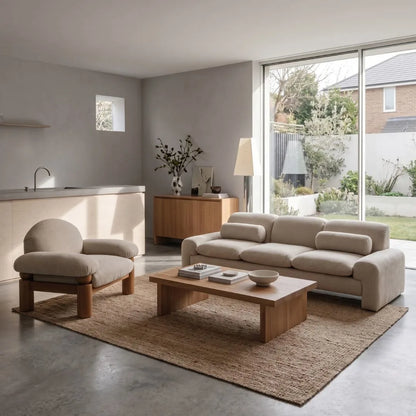 Modern living room with beige sofa, armchair, and wooden coffee table.