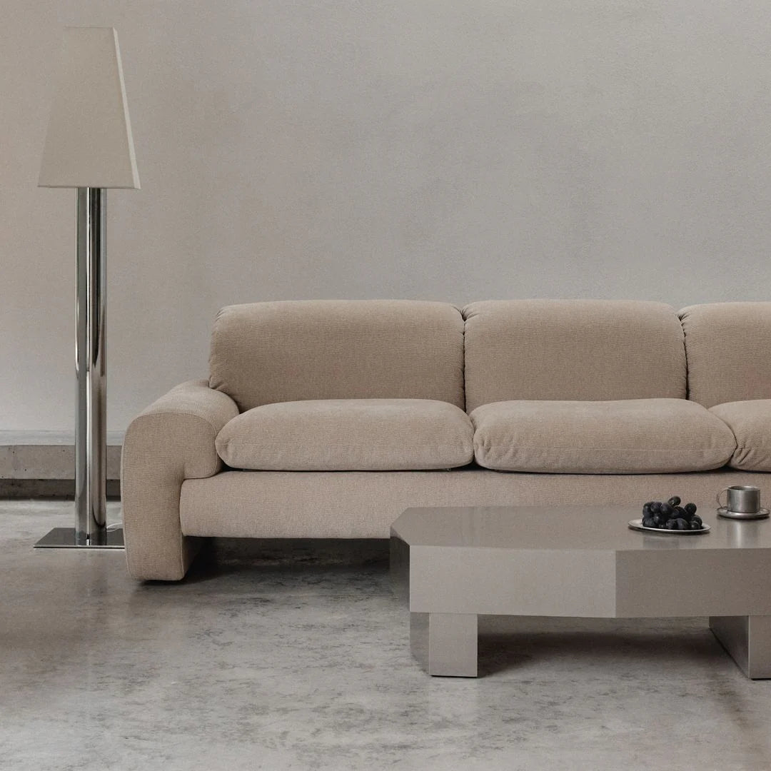 Beige sofa in a modern living room with a coffee table and floor lamp.