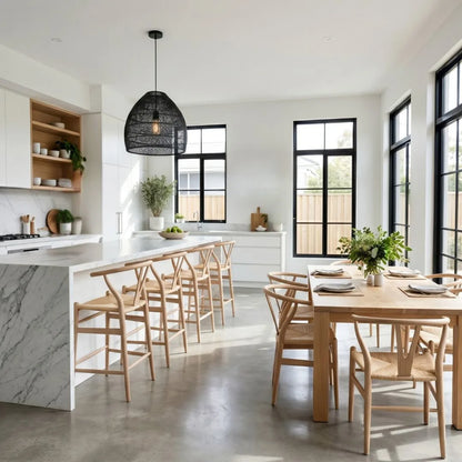 Modern kitchen with marble island, wooden dining table, and chairs.