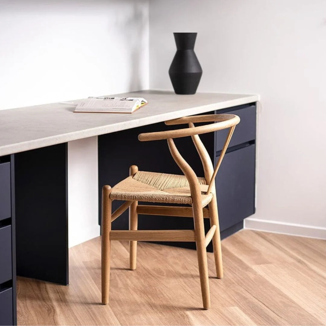 Modern desk with a wooden chair and black vase in a minimalistic setting