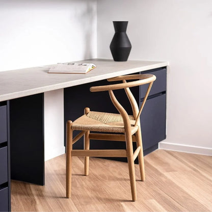 Modern desk with a wooden chair and black vase in a minimalistic setting