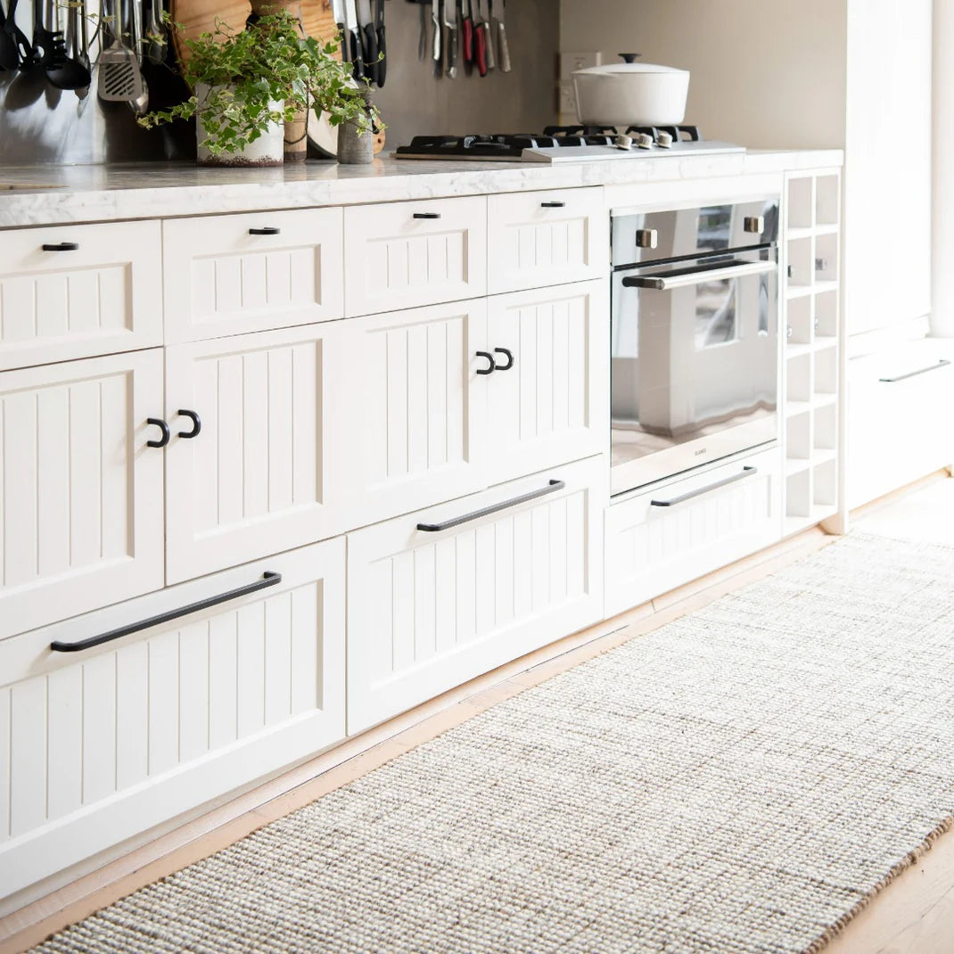 White kitchen with wooden floor and rug