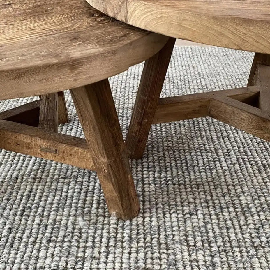 Close-up of wooden furniture on a textured grey and white blend rug