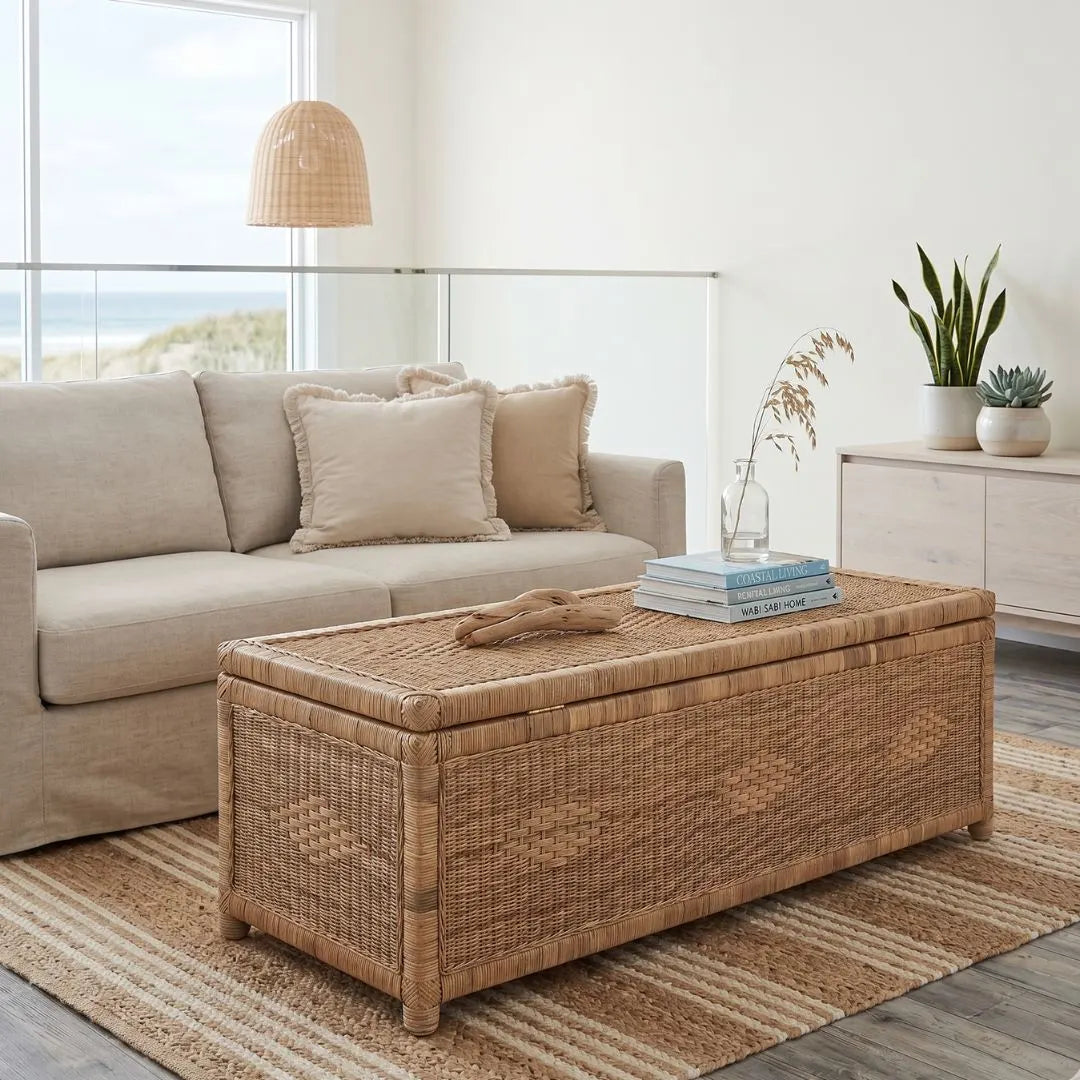 Wicker coffee table in a living room with a beige sofa and decorative items.