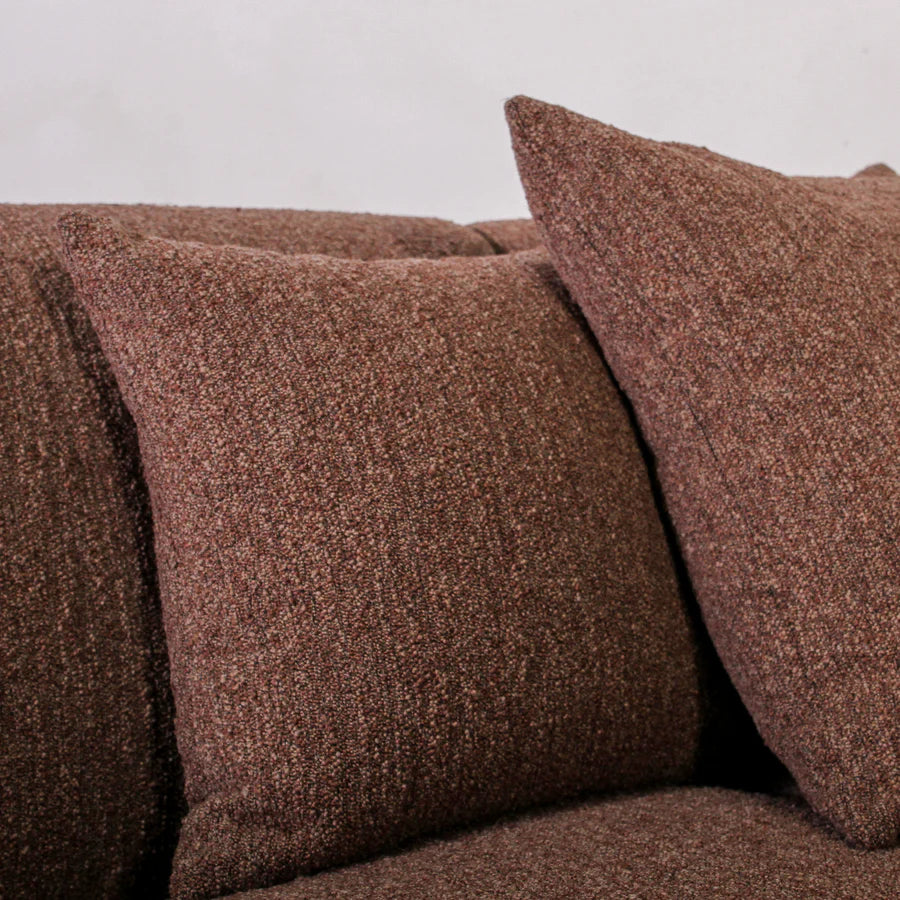 Brown textured sofa with matching cushions on a plain background