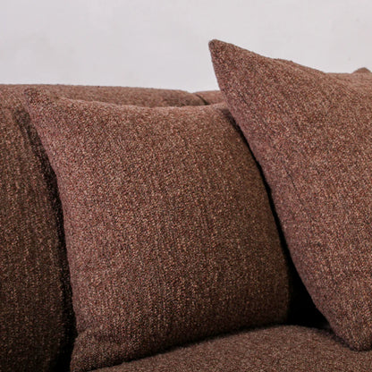 Brown textured sofa with matching cushions on a plain background