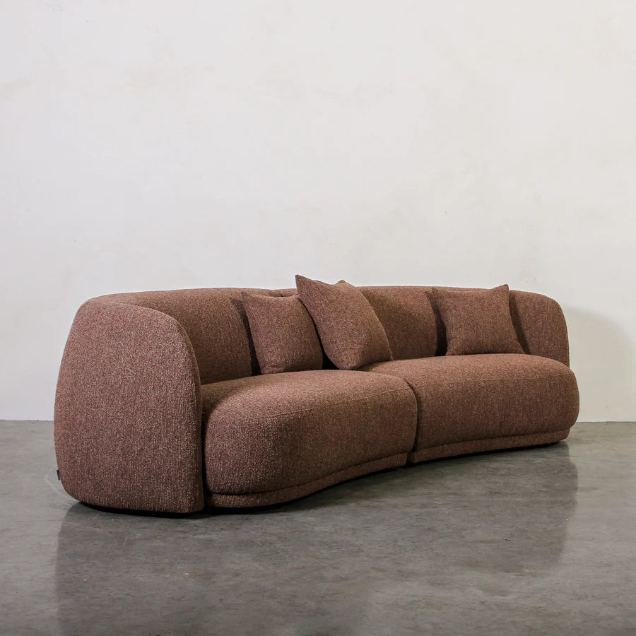 Brown sofa on a gray floor with a white wall background
