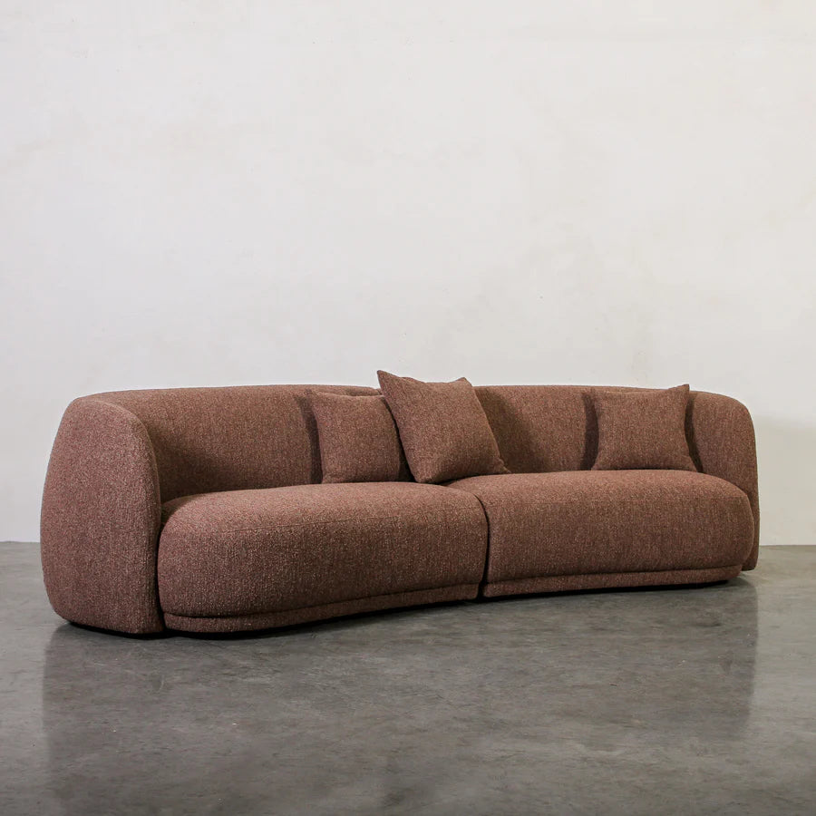 Brown sofa with cushions on a gray floor and white wall