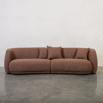 Brown sofa with cushions on a gray floor and white wall