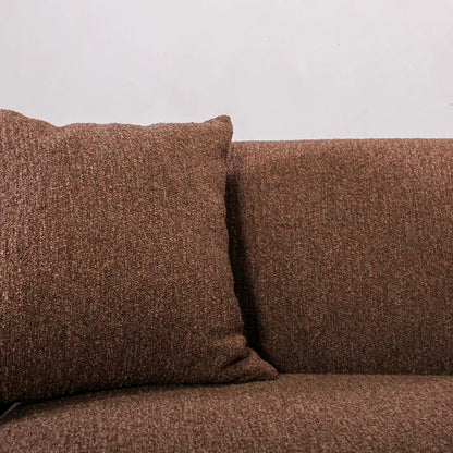 Brown textured sofa with a pillow against a light gray background