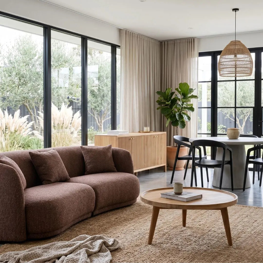 Modern living room with brown sofa, wooden coffee table, and dining area.