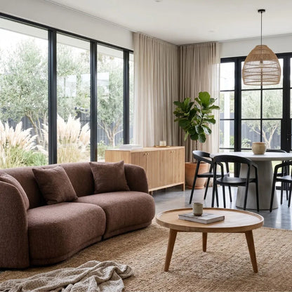 Modern living room with brown sofa, wooden coffee table, and dining area.