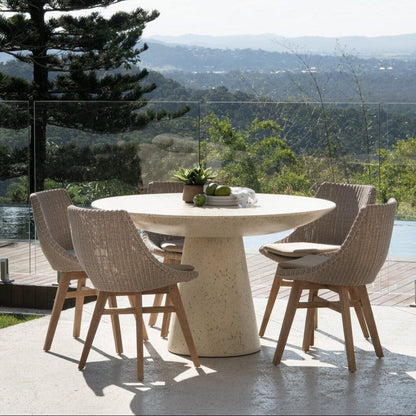 Outdoor dining table with chairs on a patio overlooking a scenic landscape.