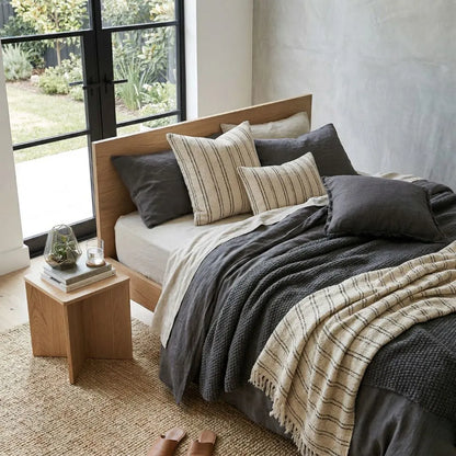 Bedroom with a wooden bed, pillows, and a nightstand with decor items.