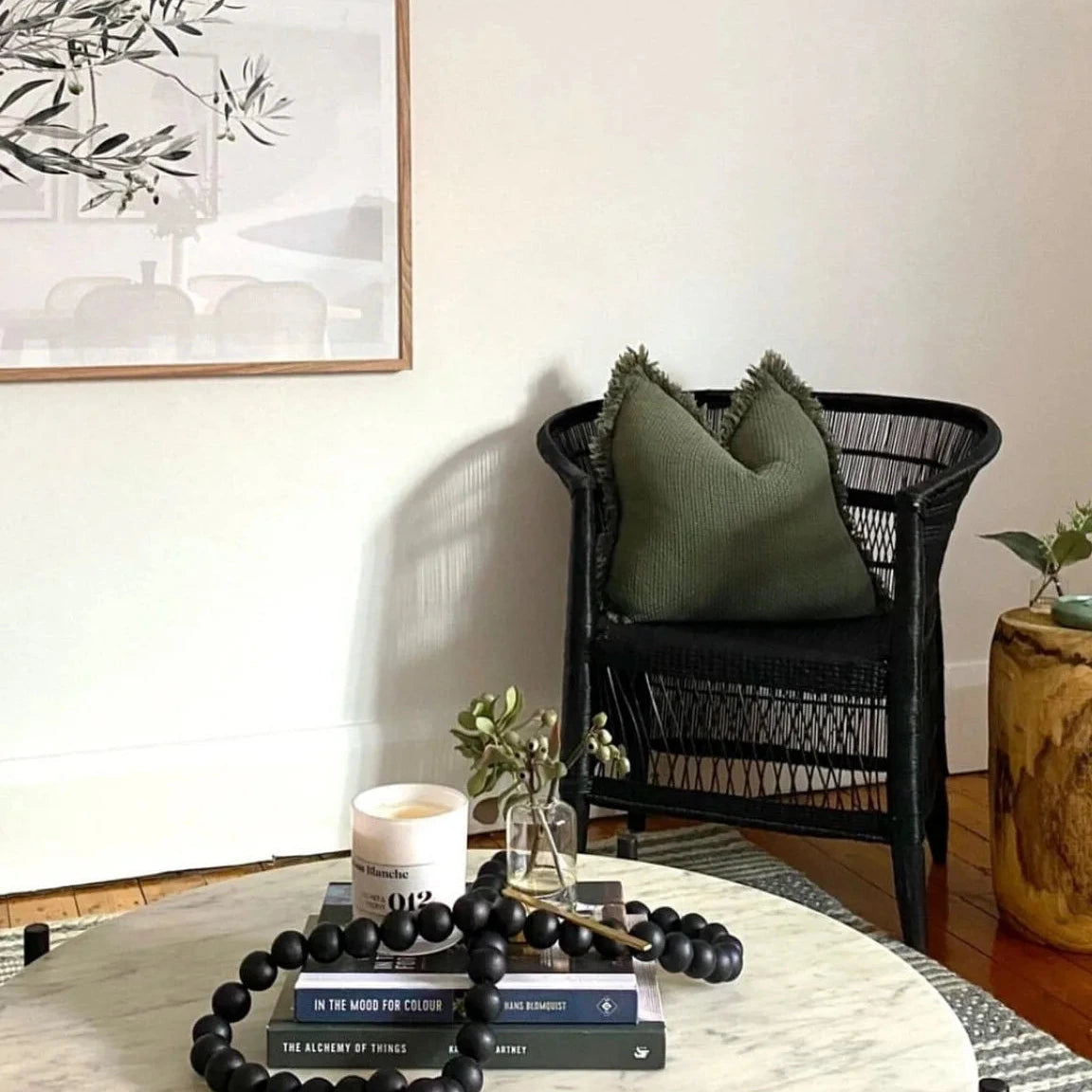 Living room with a black wicker chair, round coffee table, and decorative items.
