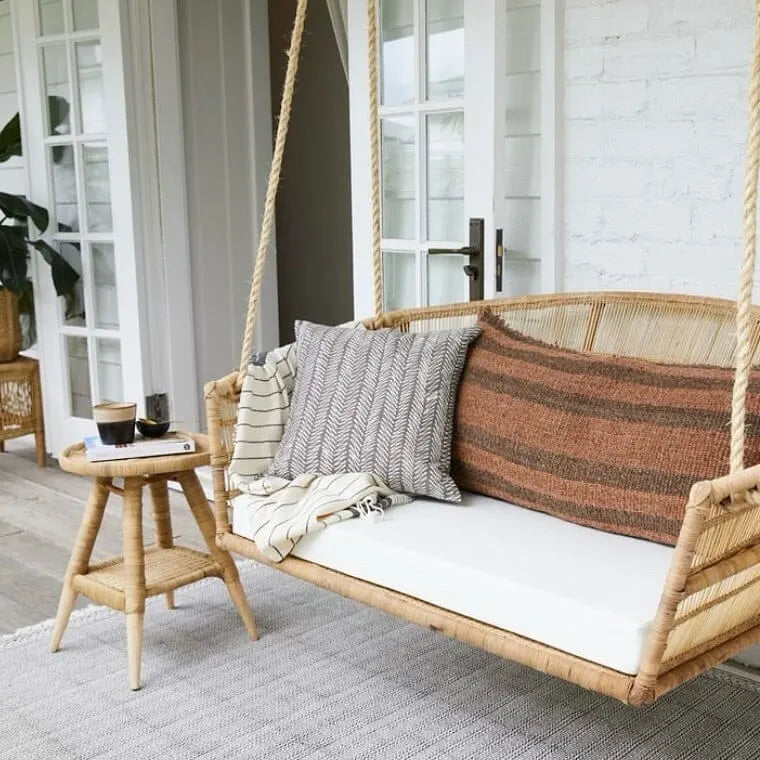Woven outdoor swing with cushions on a patio