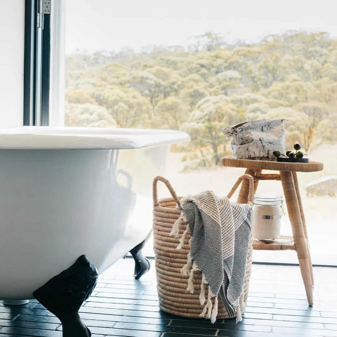 White freestanding bathtub in a bathroom with a view of trees
