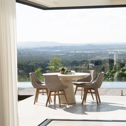 Modern dining area with a table and chairs near large windows with a scenic view.