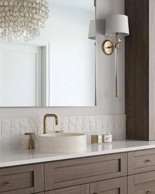 Bathroom vanity with sink, faucet, and decorative wall light fixture.