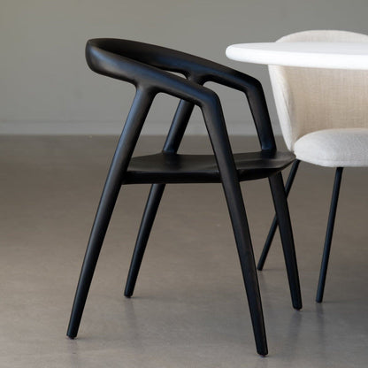 Black chair and beige chair in a room with a neutral color scheme