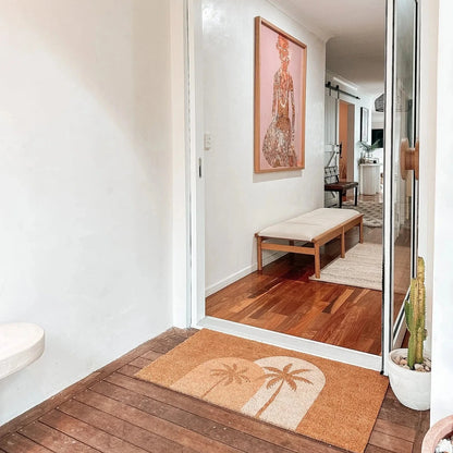 Entryway with wooden floor, doormat, and mirror reflecting interior.