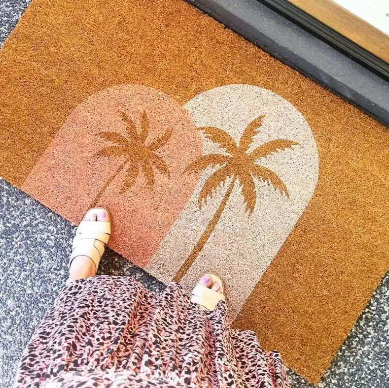 Doormat with palm tree design on a textured surface