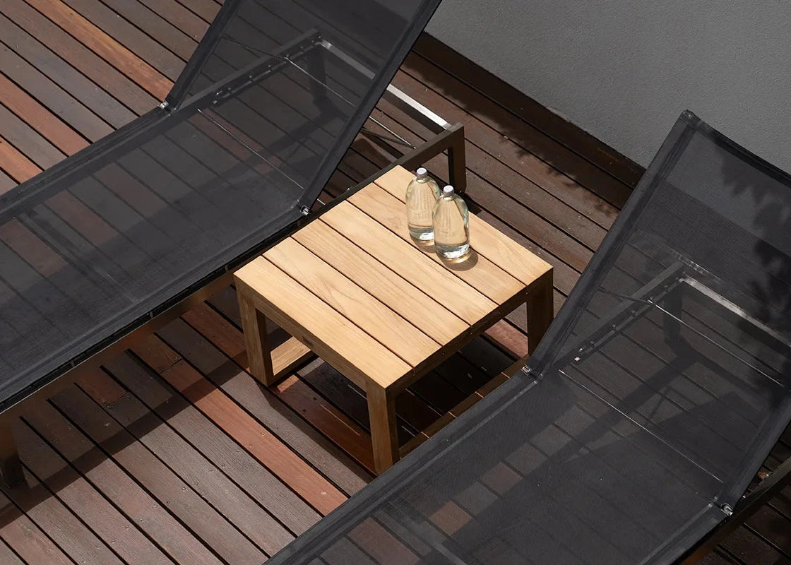 Wooden table with two bottles on a wooden deck, viewed from above
