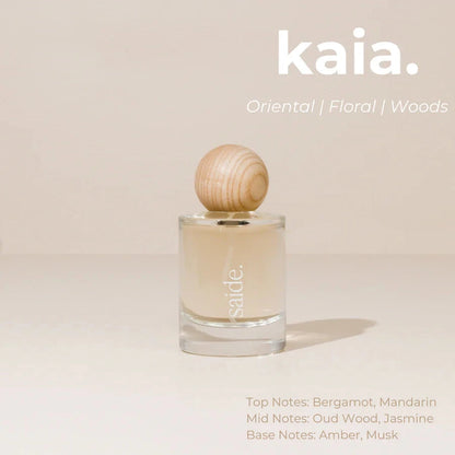 Perfume bottle with wooden cap on a beige background, featuring the brand 'kaia'.
