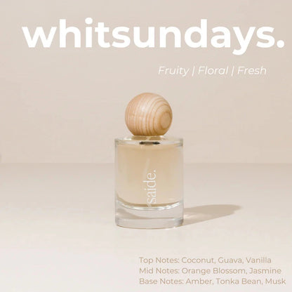 Perfume bottle with wooden cap on a beige background, featuring the brand 'whitsundays'.