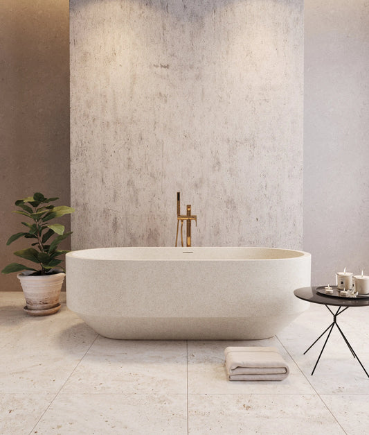 Modern bathroom with a freestanding stone bathtub against a concrete wall.